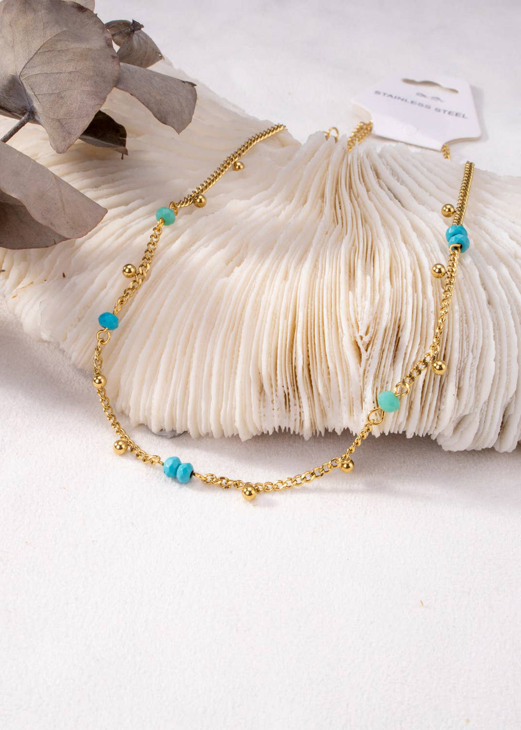 Collar dorado con pequeñas perlas azules