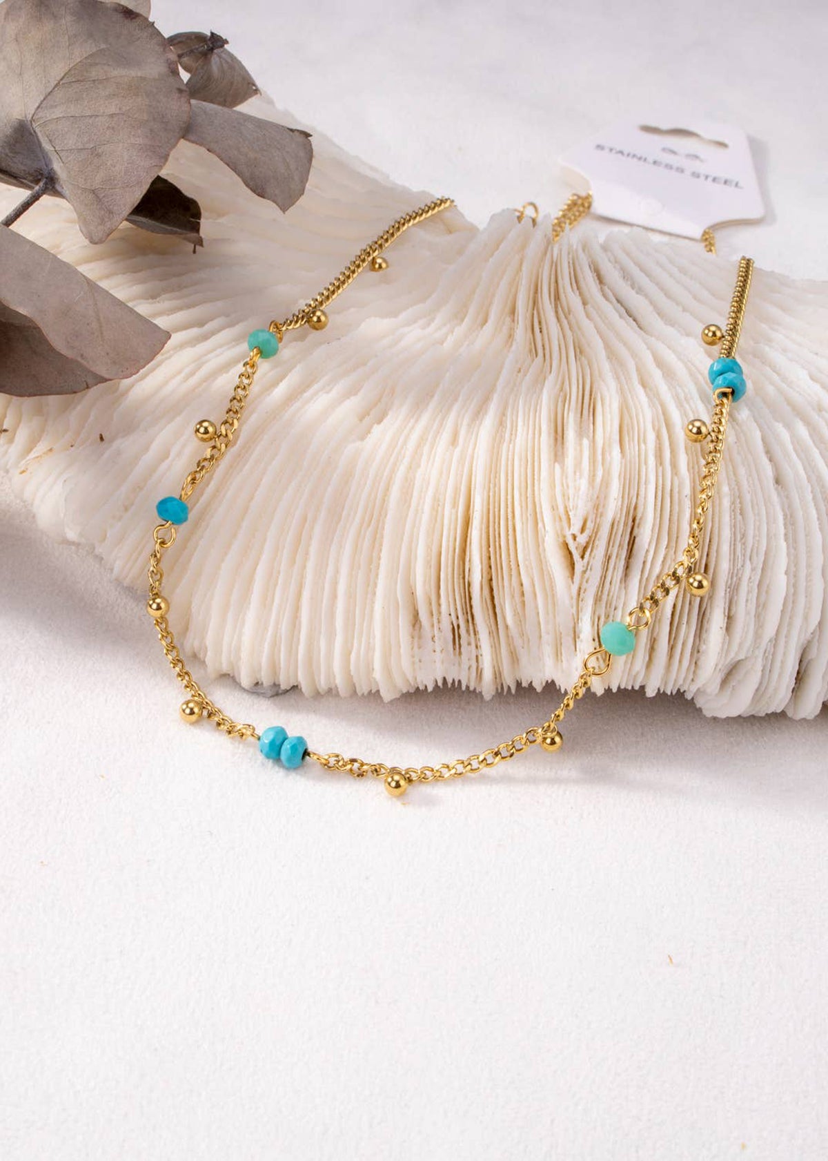 Collar dorado con pequeñas perlas azules